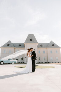 elegant wedding portraits in front of the fountain at chateau joli, a french style wedding venue in texas